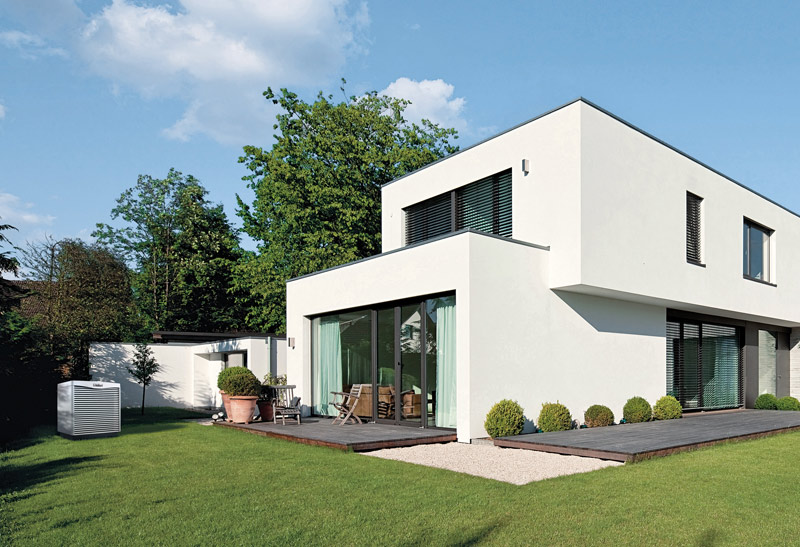 Overzichtfoto modern huis met warmtepomp in tuin